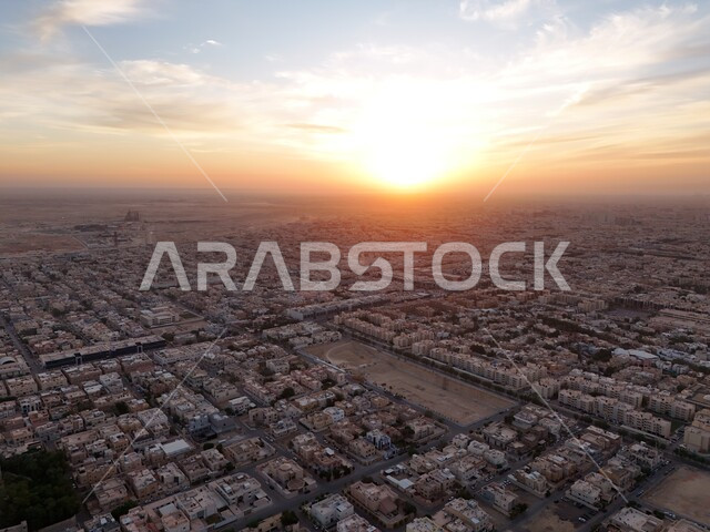 التطور والتقدم العمراني في العاصمة، صورة جوية للأحياء السكنية والمنازل في مدينة الرياض وقت غروب المشمس، الاهتمام بالبنية التحتية للطرق والشوارع في المملكة العربية السعودية، أسلوب الحياة في البلد