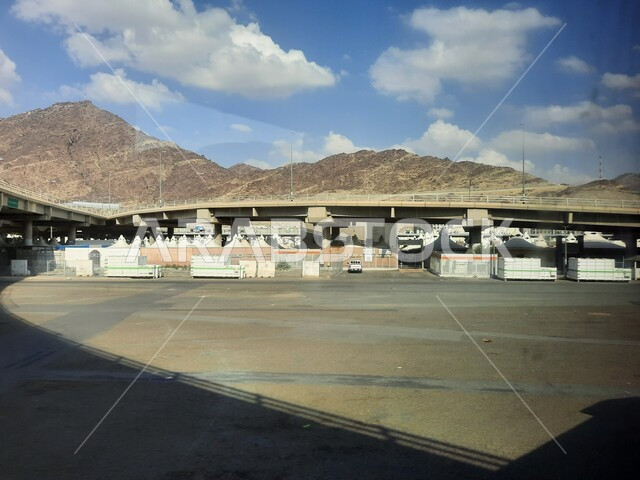 القمم و المرتفعات الجبلية في عرفات، الطرق و الشوارع المعبدة في النهار ،خيام الحجاج في مشعر منى في مكة المكرمة، موسم الحج في المملكة العربية السعودية، اداء المناسك والفرائض الدينية، اماكن اسلامية مقدسة، مفهوم العبادة والتقرب الى الله تعالى