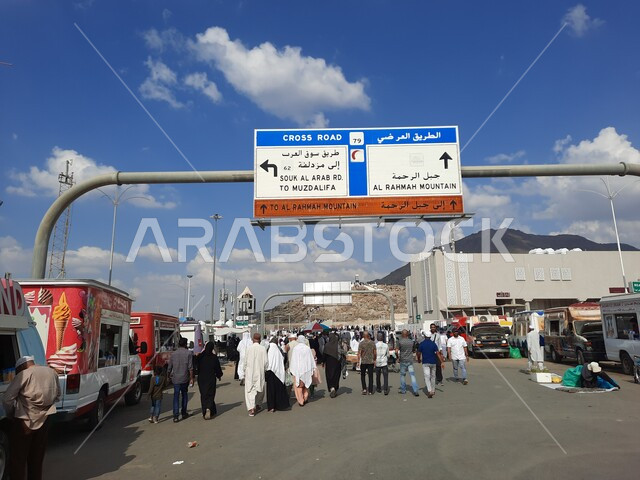 The concept of worship and getting closer to God, performing the rituals of Hajj and Umrah, sacred Islamic religious landmarks and places, a picture from the back of the pilgrims heading to the Mount of Mercy (Arafat) in Mecca during the Hajj season in the Kingdom of Saudi Arabia, banners and guidance panels.
