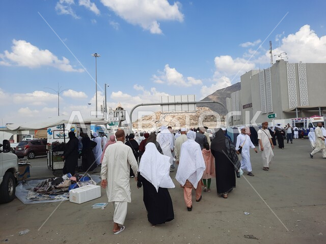 معالم واماكن اسلامية دينية مقدسة، صورة من الخلف لحجاج بيت الله الحرام يتوجهون الى جبل الرحمة (عرفة) في مكة المكرمة في موسم الحج في المملكة العربيه السعودية، اداء مناسك الحج والعمرة، مفهوم العبادة والتقرب إلى الله ،وسائل النقل والمواصلات