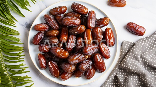 A plate full of fresh dates, delicious Ramadan hospitality, delicious healthy dates, healthy and beneficial food, a highly important nutritional meal, local Saudi national agricultural products and crops.