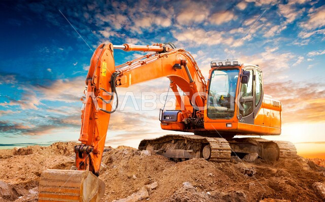 معمل تجميع الرمل والآلات الضخمة، قوة وتقنية عملية استخراج مواد البناء، آلات ومعدات ثقيلة, جرافة تعمل على رفع وتعبئة الرمال والحصى وقت غروب الشمس، مفهوم الهندسة والإنشاءات والتطوير، مهن ووظائف هندسية في السعودية