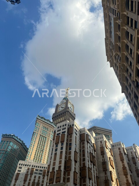 الفنادق والأبراج الفاخرة, صورة من الأسفل لمبنى برج الساعة الملكي داخل الحرام المكي الشريف في مكة المكرمة، أداء مناسك الحج والعمرة، العبادة و التقرب الى الله، منظر الغيوم البيضاء في السماء, معالم دينية اسلامية مشهورة في المملكة العربية السعودية
