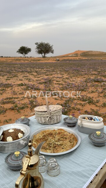 رحلة وكشتة برية في المناطق الصحراوية، دلة قهوة عربية تقليدية، صورة مقربة لمائدة طعام وسط الصحراء, الاستجمام والاستمتاع في الأجواء الهادئة, قضاء إجازة ممتعة في براري المملكة العربية السعودية