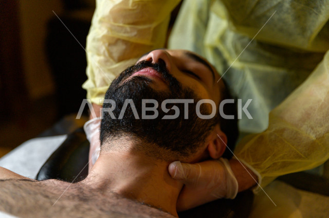 A Saudi young man gets a massage session in one of the spa centers in Saudi Arabia, the best massage services for relaxation and calm, health resorts for health and physical care, tourist places