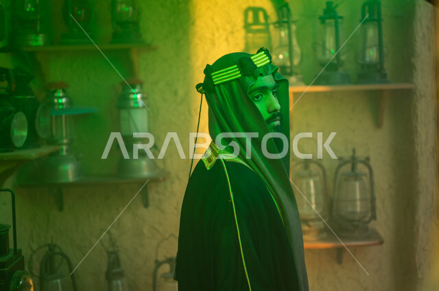 توارث حب التراث القديم من الأجداد، الفخر والاعتزاز بالهوية السعودية، ذكرى تأسيس الدولة السعودية الاولى 22 فبراير، يوم بدينا 1727 م، المناسبات والأعياد الوطنية، صورة مقربة من الخلف لرجل عربي خليجي سعودي يرتدي البشت والزي التقليدي ينظر إلى الفوانيس المعدنية