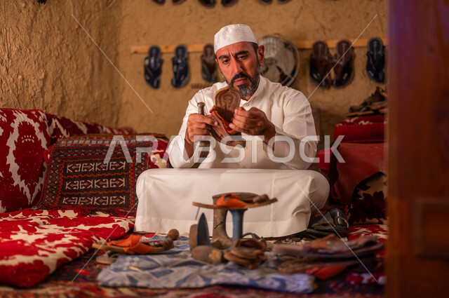المهن والحرف اليدوية التقليدية, مفهوم إحياء التراث الشعبي، أعمال وصناعات شعبية, متجر اصلاح الأحذية،  يوم بدينا 1727 م، اسكافي عربي خليجي سعودي يرتدي الثوب التقليدي والقبعه البيضاء يقوم بصناعة الحذاء وتصليحه، ذكرى تأسيس الدولة السعودية الأولى 22 فبراير