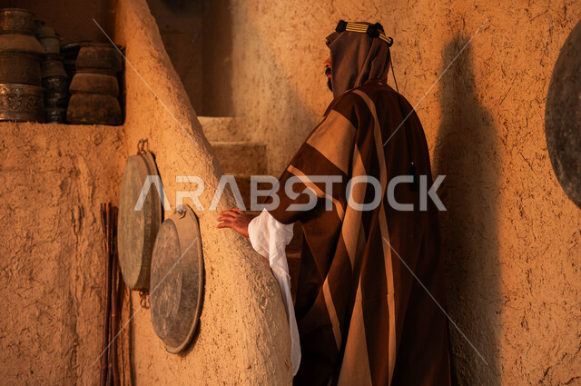 اظهار الولاء والتفاني للبلاد ،الوقوف على درج مبني من الطين في احد البيوت التراثية، ذكرى تأسيس الدولة السعودية الاولى 22 فبراير ،ارتداء الأزياء الشعبيه في الأعياد والمناسبات الوطنية ،صورة من الخلف لرجل عربي خليجي سعودي يرتدي الزي التقليدي في يوم بدينا 1727 م