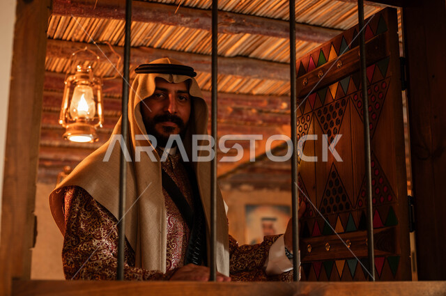 الفخر والاعتزاز بالهوية السعودية، البيوت التراثية المبنية على الطراز القديم، الأعياد والمناسبات الوطنية، يوم بدينا 1727 م، ارتداء الزي الشعبي في ذكرى تأسيس الدولة السعودية الاولى 22 فبراير، صورة مقربة لرجل عربي خليجي سعودي يرتدي الدقلة والعقال وينظر الى الكاميرا