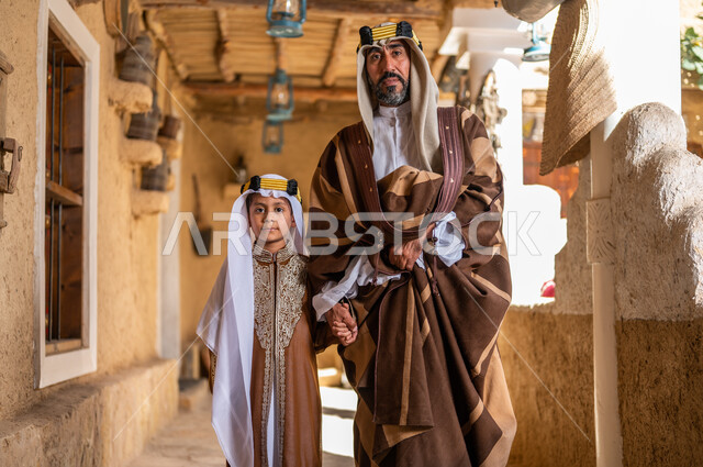 التجول في الأحياء التراثية القديمة، تعليم الأبناء الفخر والاعتزاز بالانتماء للوطن، ارتداء الأزياء الشعبيه في المناسبات الوطنية، يوم بدينا 1727 م، ذكرى تأسيس الدولة السعودية 22 فبراير، رجل عربي خليجي سعودي يرتدي العقال والبشت برفقة ابنه 