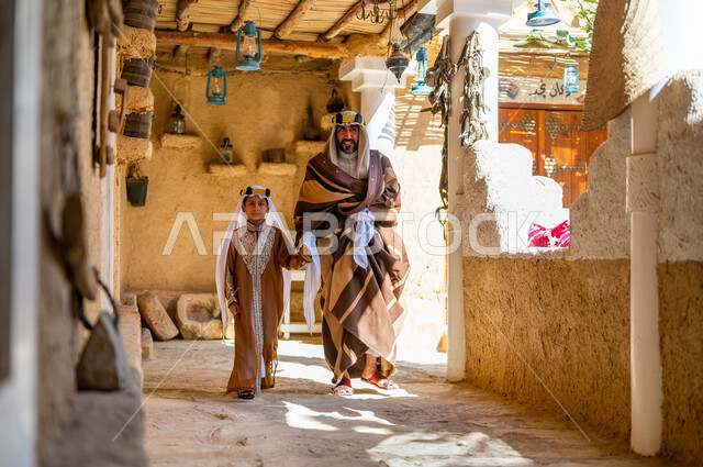 التجول في الأحياء التراثية القديمة، تعليم الأبناء الفخر والاعتزاز بالانتماء للوطن، ارتداء الأزياء الشعبيه في المناسبات الوطنية، يوم بدينا 1727 م، ذكرى تأسيس الدولة السعودية 22 فبراير، رجل عربي خليجي سعودي يرتدي العقال والبشت برفقة ابنه 