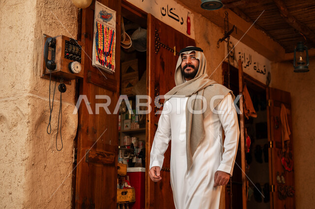 إظهار مشاعر التعلق والتمسك بالوطن, التجول في الأحياء والأسواق التراثية القديمة, الفخر والتباهي بالهوية الوطنية, شاب عربي خليجي سعودي يرتدي الزي التقليدي الخليجي ينظر إلى شيء ما, ذكرى تأسيس الدولة السعودية الأولى في 22 فبراير, يوم بدينا 1727م