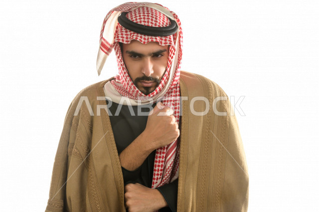 بورتريه لرجل سعودي خليجي بإيماءات الوجه التي تدل على الشعور بالبرد ، يرتدي ملابس شتوية مناسبة لفصل الشتاء ، خلفية بيضاء