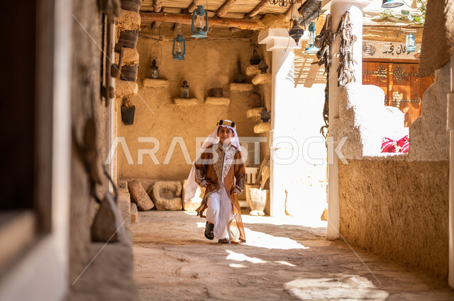 أسلوب الحياة القديمة، يوم بدينا 1727 م، تعليم الأولاد الفخر والاعتزاز بالانتماء للوطن، ارتداء الأزياء الشعبيه في المناسبات الوطنية، ذكرى تأسيس الدولة السعودية 22 فبراير، ولد عربي خليجي سعودي يرتدي العقال والبشت يركض بين البيوت والأحياء التراثية 