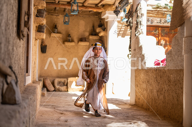 نمط الحياة القديمة، يوم بدينا 1727 م، تعليم الأولاد الفخر والاعتزاز بالانتماء للوطن، ارتداء الأزياء الشعبيه في المناسبات الوطنية، ذكرى تأسيس الدولة السعودية 22 فبراير، ولد عربي خليجي سعودي يرتدي العقال والبشت يركض بين البيوت والأحياء التراثية 