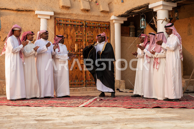 الاحياء التراثية الطينية القديمة، عروض فرق الفلكلور التراثي في المناسبات الوطنية، ارتداء الأزياء الشعبية التقليدية والبشت في المناسبات، ذكرى تأسيس الدولة السعودية الأولى، مجموعة من الرجال العرب الخليجيين السعوديين يقومون بالغناء والرقص احتفالا بيوم بدينا١٧٢٧
