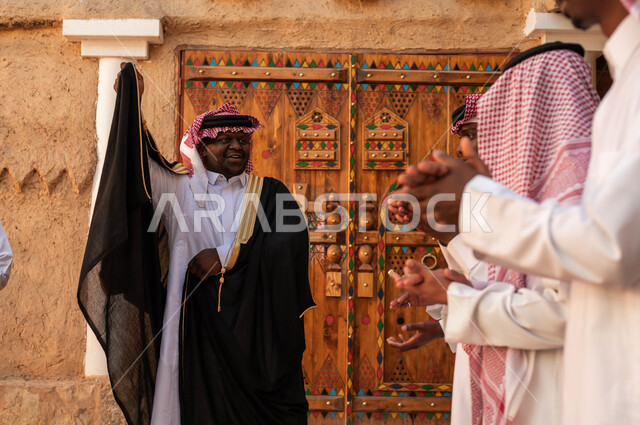 عروض فرق الفلكلور التراثي في المناسبات الوطنية، الاحياء التراثية الطينية القديمة، أزياء العرضة النجدية الشعبية، المشاركة في الفعاليات والأعياد والمهرجانات الوطنية ، رجل عربي خليجي سعودي يقوم بالرقص والاحتفال بذكرى تأسيس الدولة السعودية ٢٢فبراير، يوم بدينا١٧٢٧