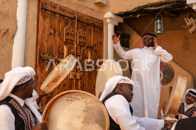الغناء والرقص الشعبي وقرع الطبول احتفالا بيوم بدينا ١٧٢٧، عروض فرق الفلكلور التراثي في المناسبات الوطنية، إيماءات الفرح والسعادة، ارتداء أزياء العرضه النجدية الشعبية، مجموعة من الرجال العرب الخليجيين السعوديين يقومون بالاحتفال بذكرى تأسيس الدولة السعودية ٢٢فبراير