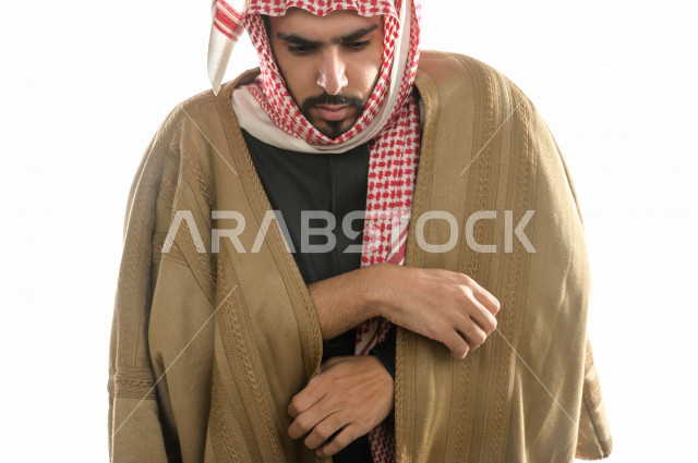 بورتريه لرجل سعودي خليجي بإيماءات الوجه التي تدل على الشعور بالبرد ، يرتدي ملابس شتوية مناسبة لفصل الشتاء ، خلفية بيضاء