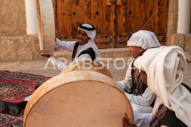 ارتداء الأزياء التقليدية التراثية في المناسبات الوطنية، المشاركة في الفعاليات والأعياد والمهرجانات الشعبية، إظهار الولاء والحب للدولة السعودية، الأحياء الطينية القديمة، صورة مقربة من الجانب لفرقة عربية خليجية سعودية تقوم بقرع الطبول احتفالا بيوم بدينا١٧٢٧