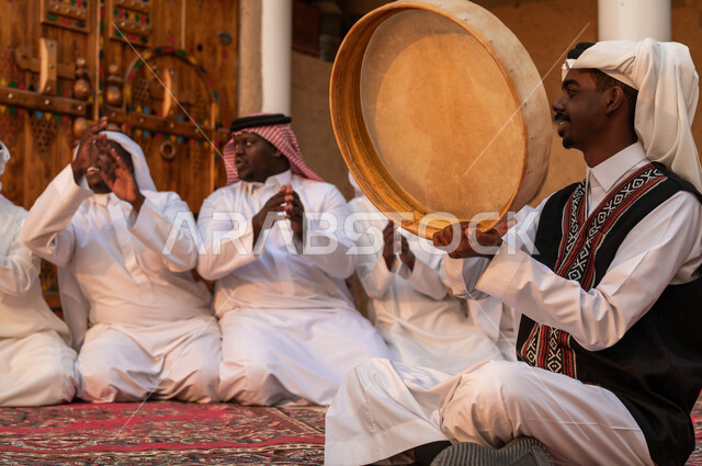 التصفيق والرقص وقرع الطبول احتفالا بيوم بدينا ١٧٢٧، عروض فرق الفلكلور التراثي في المناسبات الوطنية، إيماءات الفرح والسرور، ارتداء أزياء العرضه النجدية الشعبية، مجموعة من الرجال العرب الخليجيين السعوديين يقومون بالاحتفال بذكرى تأسيس الدولة السعودية ٢٢فبراير