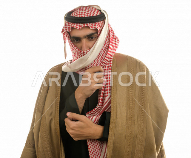 بورتريه لرجل سعودي خليجي بإيماءات الوجه التي تدل على الشعور بالبرد ، يرتدي ملابس شتوية مناسبة لفصل الشتاء ، خلفية بيضاء