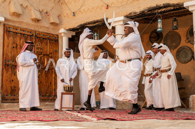 تخليد ذكرى إعادة توحيد الوطن, ايماءات الفرح والاندماج مع الرقص الشعبي احتفالا بيوم بدينا 1727, مجموعة من الرجال العرب السعوديين الخليجيين يرتدون الزي التقليدي, الرقص وقرع الطبول احتفالا بيوم التأسيس 22 فبراير, الاحياء الطينية التراثية القديمة
