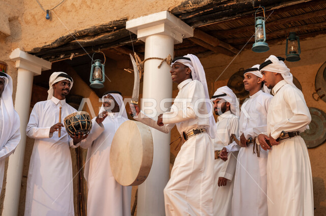 الرقص والمشاركة في المناسبات والاحتفالات الوطنية, الفخر والاعتزاز بالانتماء للبلاد, مجموعة من الرجال العرب السعوديين الخليجيين يرتدون الزي التقليدي يقومون بالاحتفال بذكرى تأسيس الدولة السعودية 22 فبراير, عروض فرق الفلكلور في يوم بدينا 1727