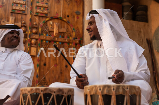 النظر بإيماءات السعادة والاندماج مع الرقص الشعبي وقرع الطبول احتفالا بيوم بدينا 1727, تخليد ذكرى إعادة توحيد الوطن, صورة مقرب لرجل عربي سعودي خليجي يرتدي الزي الشعبي التقليدي والعقال في المناسبات الوطنية, عروض الفلكلور الشعبي, تأسيس الدولة السعودية 22 فبراير