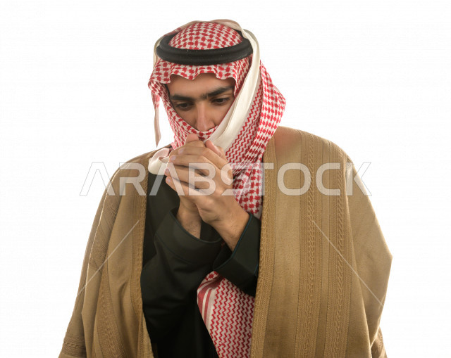 بورتريه لرجل سعودي خليجي بإيماءات الوجه التي تدل على الشعور بالبرد ، يرتدي ملابس شتوية مناسبة لفصل الشتاء ، خلفية بيضاء