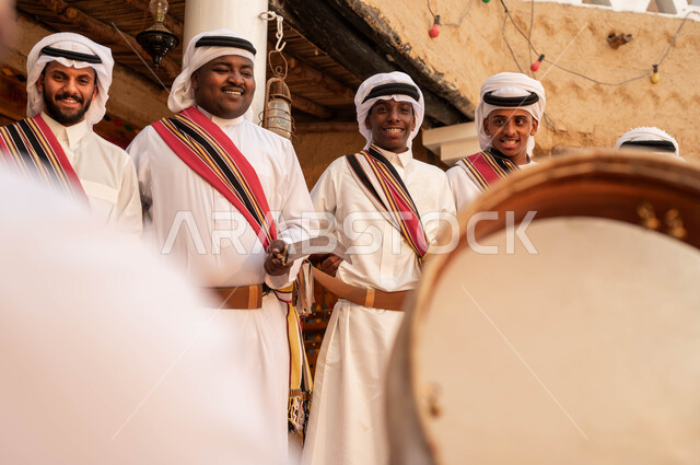 إيماءات الفرح والاندماج مع الرقص الشعبي والاهازيج احتفالا بيوم بدينا ١٧٢٧، عروض فرق الفلكلور في المناسبات الوطنية, مجموعة من الرجال العرب الخليجيين السعوديين يقومون بالاحتفال بذكرى تأسيس الدولة السعودية ٢٢فبراير، ارتداء أزياء العرضه النجدية الشعبية