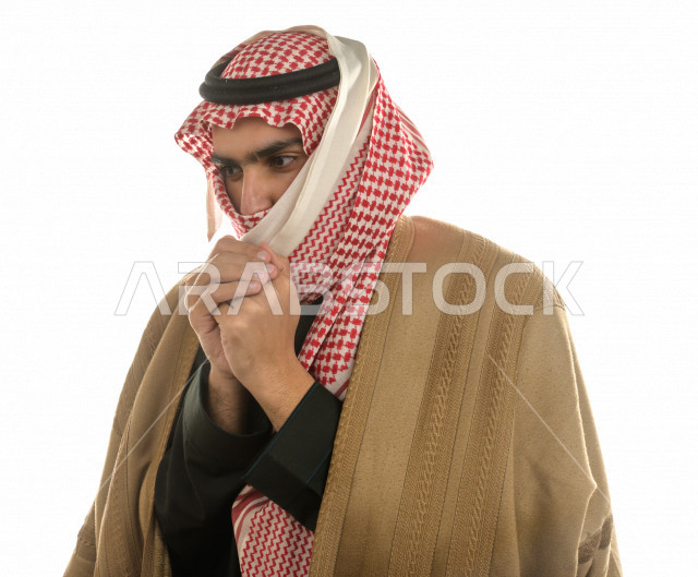 بورتريه لرجل سعودي خليجي بإيماءات الوجه التي تدل على الشعور بالبرد ، يرتدي ملابس شتوية مناسبة لفصل الشتاء ، خلفية بيضاء