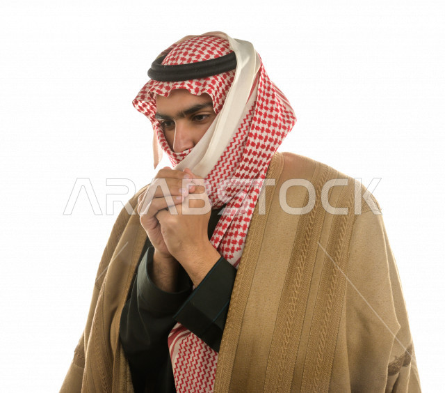 بورتريه لرجل سعودي خليجي بإيماءات الوجه التي تدل على الشعور بالبرد ، يرتدي ملابس شتوية مناسبة لفصل الشتاء ، خلفية بيضاء