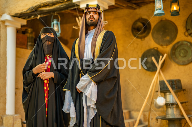 الوقوف بإيماءات الفخر والاعتزاز، يوم بدينا 1727 م، ارتداء الزي الشعبي في ذكرى تأسيس الدولة السعودية الاولى 22 فبراير،  زوجان عربيان خليجيان سعوديان يرتديان الزي التقليدي للمناسبات والأعياد الوطنية، البيوت التراثية القديمة