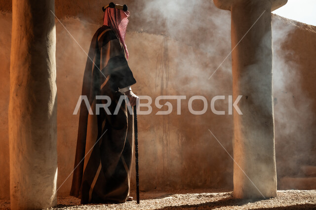 ذكرى تأسيس الدولة السعودية الأولى في 22 فبراير, التجول بالأحياء والمنشآت الطينية التراثية القديمة, صورة من الجانب الرجل عربي خليجي سعودي يرتدي البشت والعقال يحمل العكاز, ارتداء الأزياء الشعبية التقليدية في الأعياد والمناسبات الوطنية, يوم بدينا 1727 م