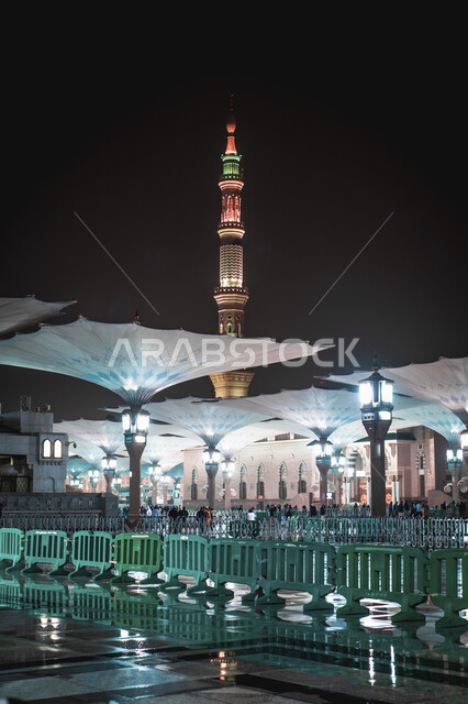 منظر الحرم النبوي الشريف في المملكة العربية السعودية ليلا، المظلات الإلكترونية في ساحة مسجد رسول الله في المدينة المنورة، العبادة والتقرب الى الله، أماكن دينية إسلامية مقدسة، المسلمون يمشون في المجمع الخارجي للجامع