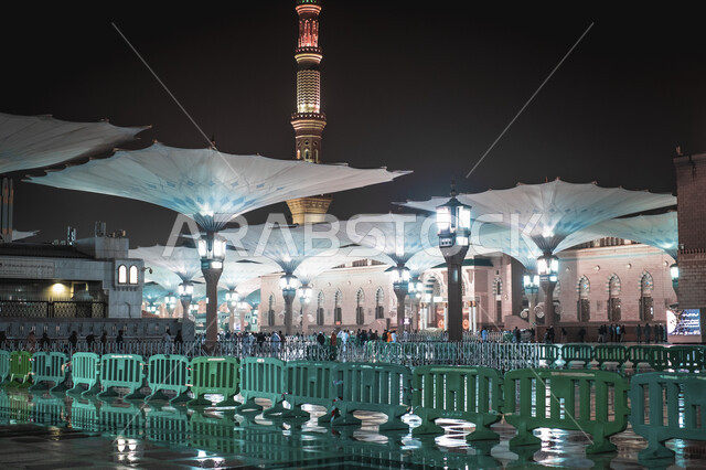 منظر الحرم النبوي الشريف في المملكة العربية السعودية ليلا، المظلات الإلكترونية في ساحة مسجد رسول الله في المدينة المنورة، العبادة والتقرب الى الله، أماكن دينية إسلامية مقدسة، المسلمون يمشون في المجمع الخارجي للجامع