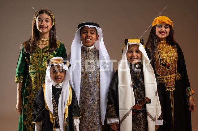 النظر إلى الكاميرا بتعابير الفرح والسرور، الفخر بإنجازات البلاد, تعليم الأبناء الفخر والاعتزاز بالهوية الوطنية، يوم بدينا 1727 م، بورتريه لمجموعة أولاد عرب خليجيين سعوديين يرتدون الزي التقليدي الشعبي التقليدي، ذكرى تأسيس الدولة السعودية 22 فبراير، خلفية بيج