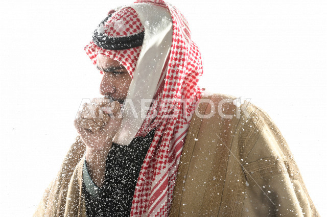 بورتريه لرجل سعودي خليجي بإيماءات الوجه التي تدل على الشعور بالبرد ، يرتدي ملابس شتوية مناسبة لفصل الشتاء ، خلفية بيضاء
