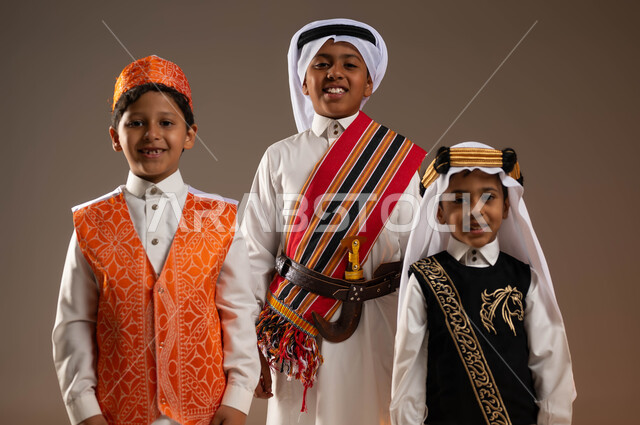 مشاركة الأطفال في المناسبات الوطنية, تعليم الأبناء الفخر والاعتزاز بأنجازات الوطن، يوم بدينا 1727 م، بورتريه مقرب لمجموعة أولاد عرب خليجيين سعوديين يرتدون الأزياء الشعبية التقليدية، ذكرى تأسيس الدولة السعودية 22 فبراير, النظر إلى الكاميرا بسرور, خلفية بيج
