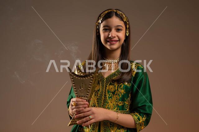 يوم بدينا 1727 م، التطيب بالعود والبخور، ذكرى تأسيس الدولة السعودية 22 فبراير، ارتداء أزياء المنطقة الوسطى، بورتريه مقرب لفتاة عربية خليجية سعودية مبتسمة ترتدي المقطع والحزام تحمل بيدها المبخرة تنظر إلى الكاميرا بإيماءات السرور والسعادة خلفية بيج