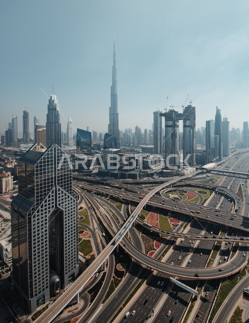 The network of paved roads and streets, advanced architectural engineering art for towers and skyscrapers, work on developing and developing buildings, an aerial photo of Burj Khalifa in the Emirate of Dubai during the day, famous tourist attractions in the United Arab Emirates