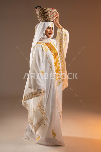 مهن وحرف يدوية نسائية قديمة، يوم بدينا 1727 م، ارتداء أزياء المنطقة الشرقية في المناسبات الوطنية، بورتريه لإمرأة عربية خليجية سعودية مبتسمة ترتدي الشيلة والنشل تضع على رأسها سلة قش، ذكرى تأسيس الدولة السعودية الأولى في 22 فبراير، صورة لكامل الجسم، خلفية بيج