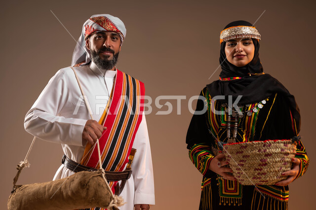 مهن وحرف يدوية قديمة, الثقة والفخر بإنجازات البلاد, إظهار الولاء والحب للوطن, بورتريه مقرب لرجل وامرأة عربيان خليجيان سعوديان يرتديان الأزياء الشعبية التقليدية في المناسبات الوطنية, يوم بدينا 1727م, ذكرى تأسيس الدولة السعودية الأولى في 22 فبراير, خلفية بيج