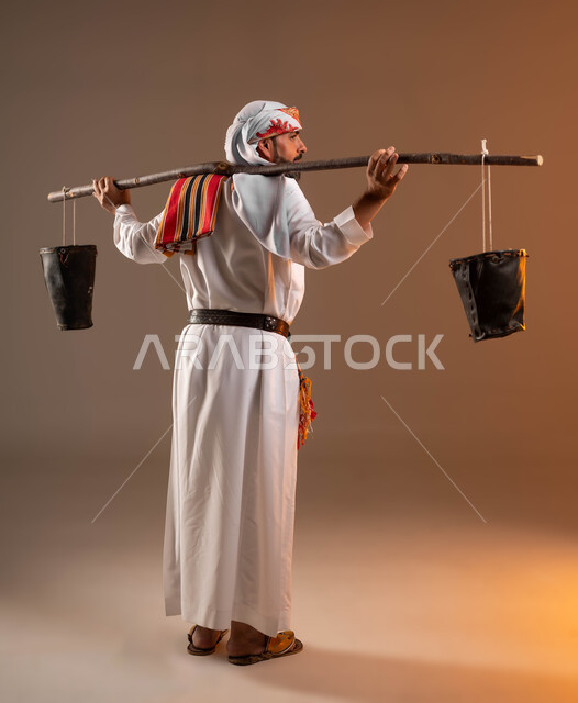 Founding of the first Saudi state, February 22, a water sower goes around watering people from the well, the Day of Dina 1727 AD, wearing the costumes of the southern region, a portrait from the back of a Saudi Gulf Arab man wearing a thobe, a ghutra, and a southern shawl holding a leather bucket, full-length body portrait, beige background