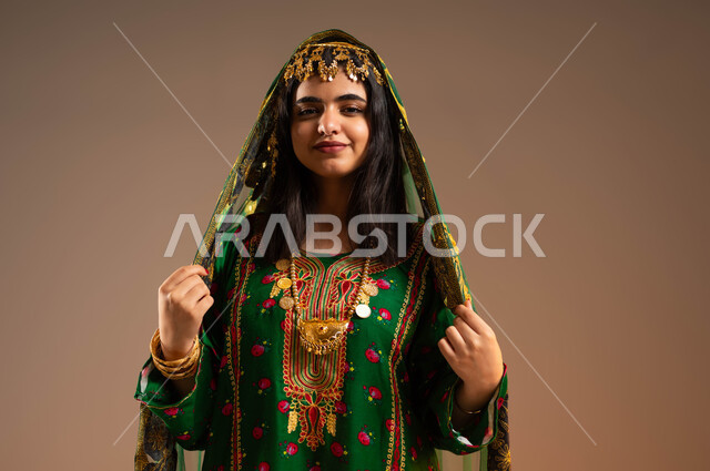 Gestures of happiness and pride in belonging to the Kingdom, taking care of the external appearance, the concept of elegance and beautification, a close-up portrait of a Saudi Gulf Arab woman wearing a shayla, hama and bisht, wearing the fashions of the central region, the anniversary of the founding of the first Saudi state, February 22, Day of Dina 1727 AD, beige background
