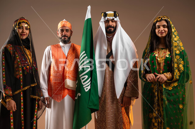 رفع علم التأسيس باحترام واعتزاز, الفخر بإنجازات البلاد, بورتريه لمجموعة رجال ونساء عرب خليجين سعوديين يرتدون زي يوم التأسيس, ذكرى تأسيس الدولة السعودية الأولى في 22 فبراير, يوم بدينا 1727م, ارتداء الأزياء التقليدية الشعبية في المناسبات الوطنية, خلفية بيج