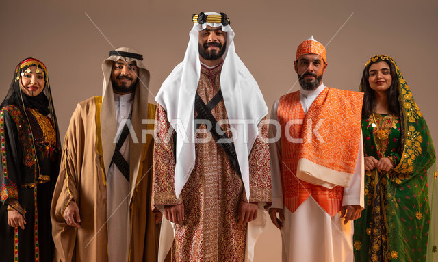 التباهي والفخر والاعتزاز بالانتماء العربي السعودي, ذكرى تأسيس الدولة السعودية الأولى في 22 فبراير, بورتريه لمجموعة رجال ونساء عرب خليجين سعوديين يرتدون الأزياء التقليدية الشعبية في المناسبات الوطنية ينظرون إلى الكاميرا, يوم بدينا 1727م, خلفية بيج