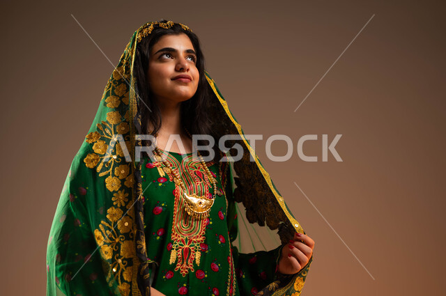 ذكرى تأسيس الدولة السعودية الأولى في 22 فبراير, التباهي بإنجازات الوطن, بورتريه مقرب لشابة عربية خليجية سعودية ترتدي المقطع والهامة والبشت تنظر إلى شيء ما, ارتداء أزياء المنطقة الوسطى في المناسبات الوطنية, يوم بدينا 1727م, خلفية بيج