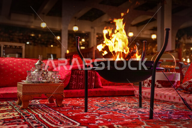 العادات والتقاليد السعودية في تقديم القهوة العربية بالدله والفنجان، صورة مقربة لمجلس عربي شعبي فاخر، التدفئة على موقد الحطب في الأجواء الشتوية، جلسات شعبية تلقيدية